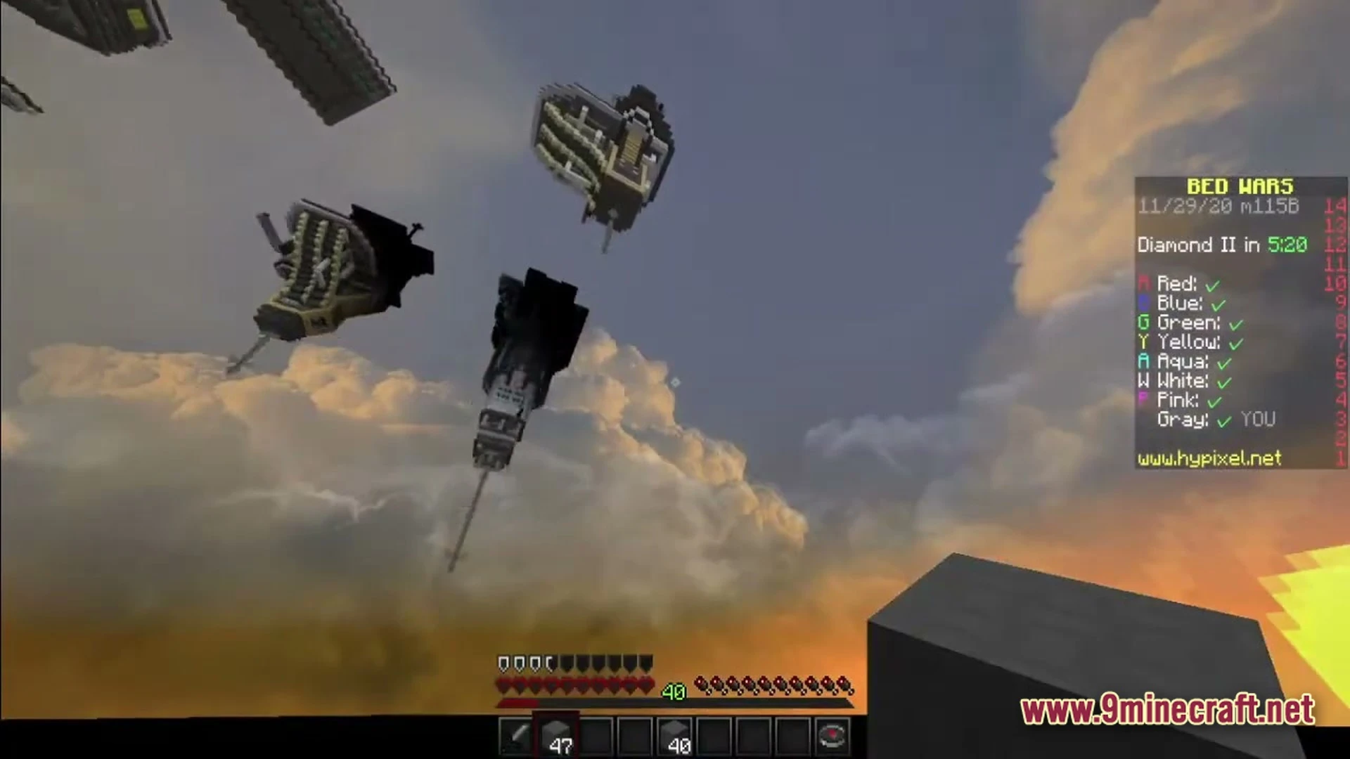 Floating islands and structures in a bed wars match under a cloudy sunset sky