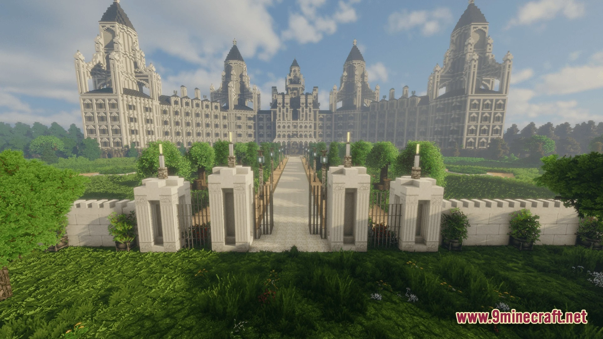 A large white stone mansion with multiple towers and a gated garden path under a clear sky