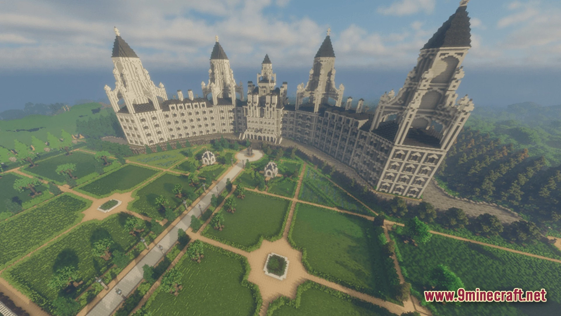 A massive white stone palace with multiple towers overlooks a sprawling landscaped garden with pathways