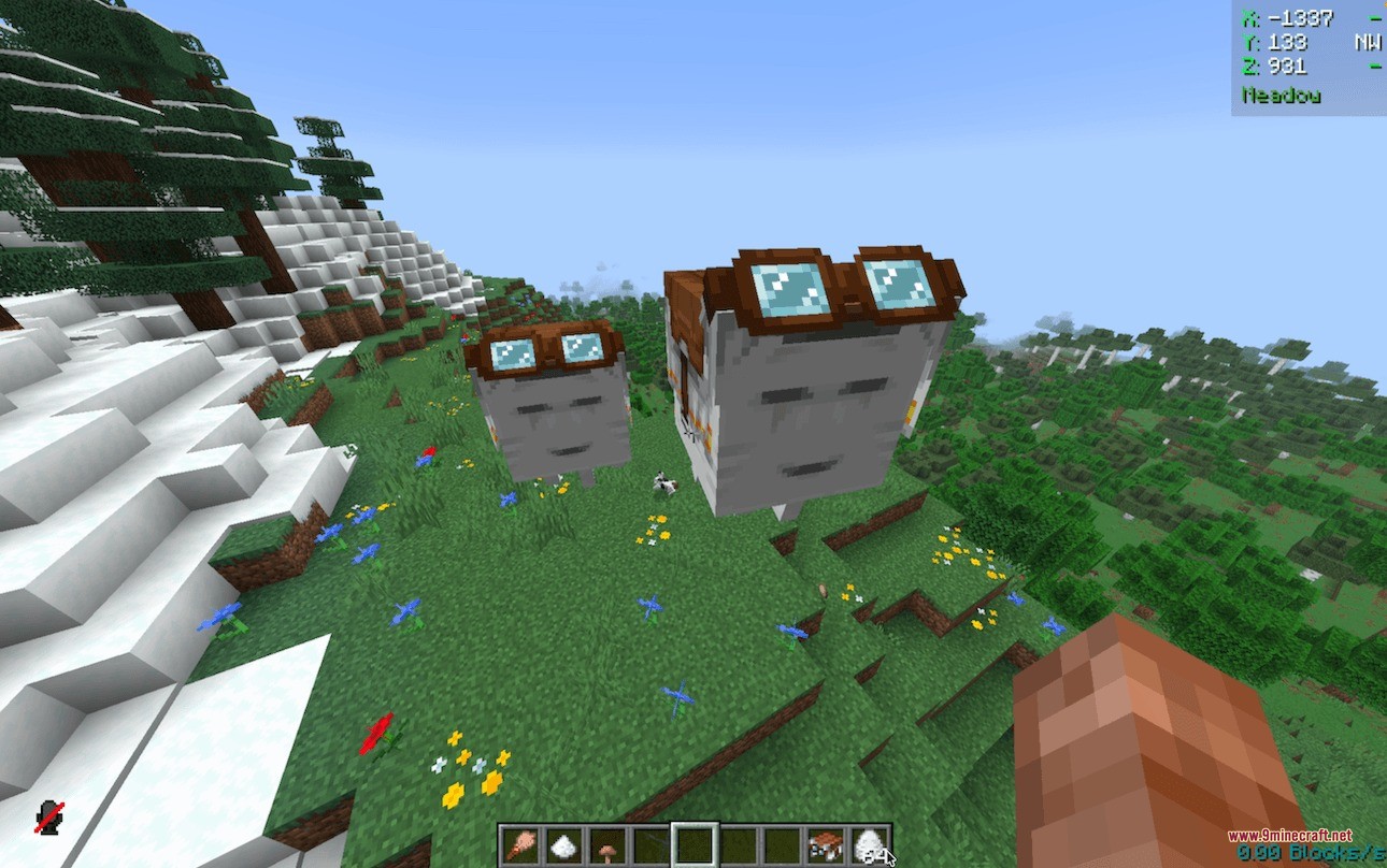 Two small ghasts wearing goggles float together on a green grassy hill