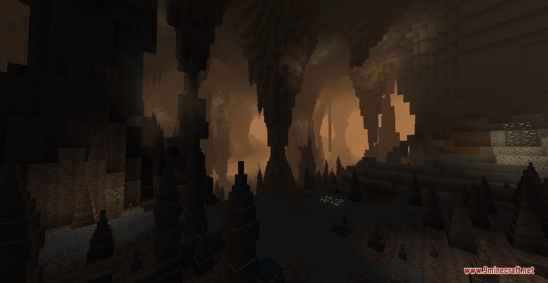 A massive underground dripstone cave filled with a thick and dusty orange fog