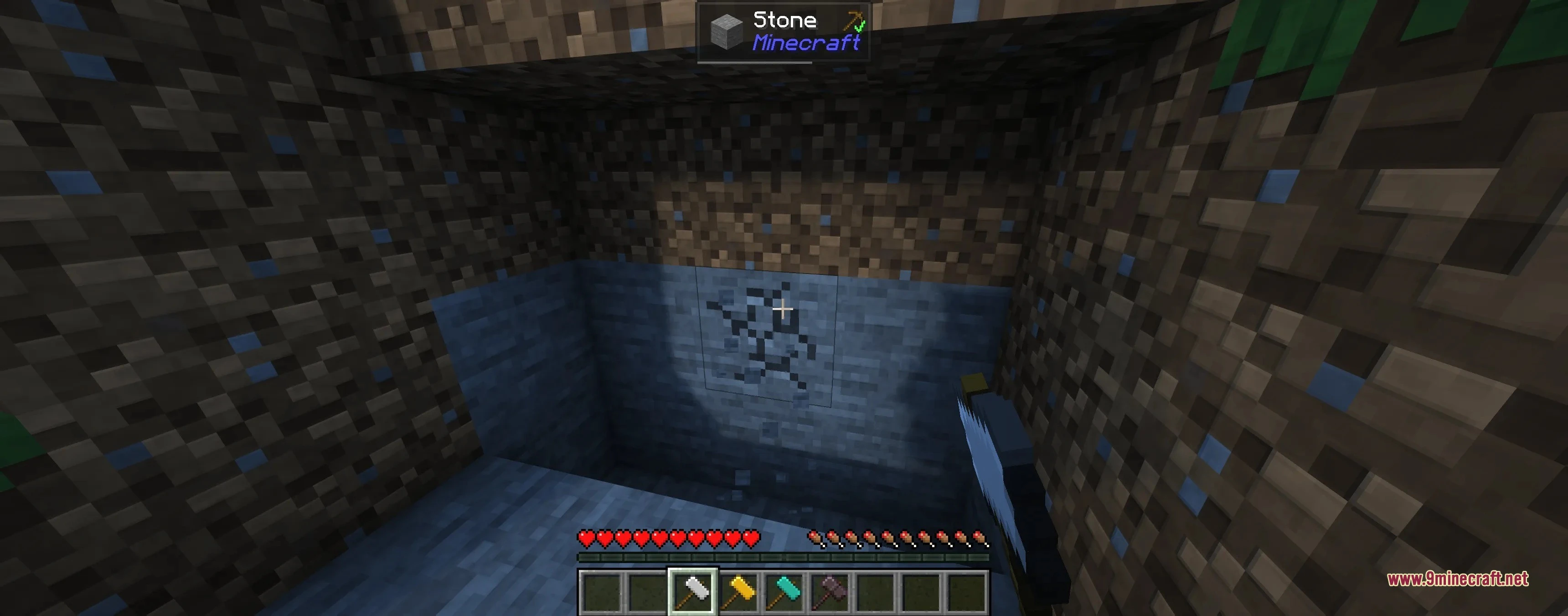 Player mining a large area of stone blocks with a heavy white hammer