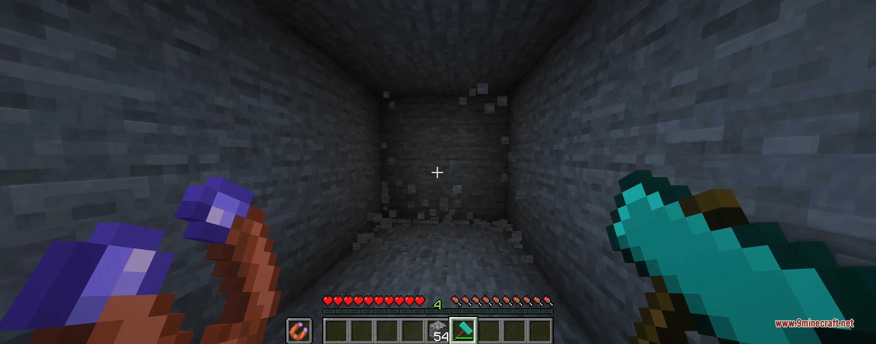 Player holding a diamond hammer and magnet while mining in a stone cave