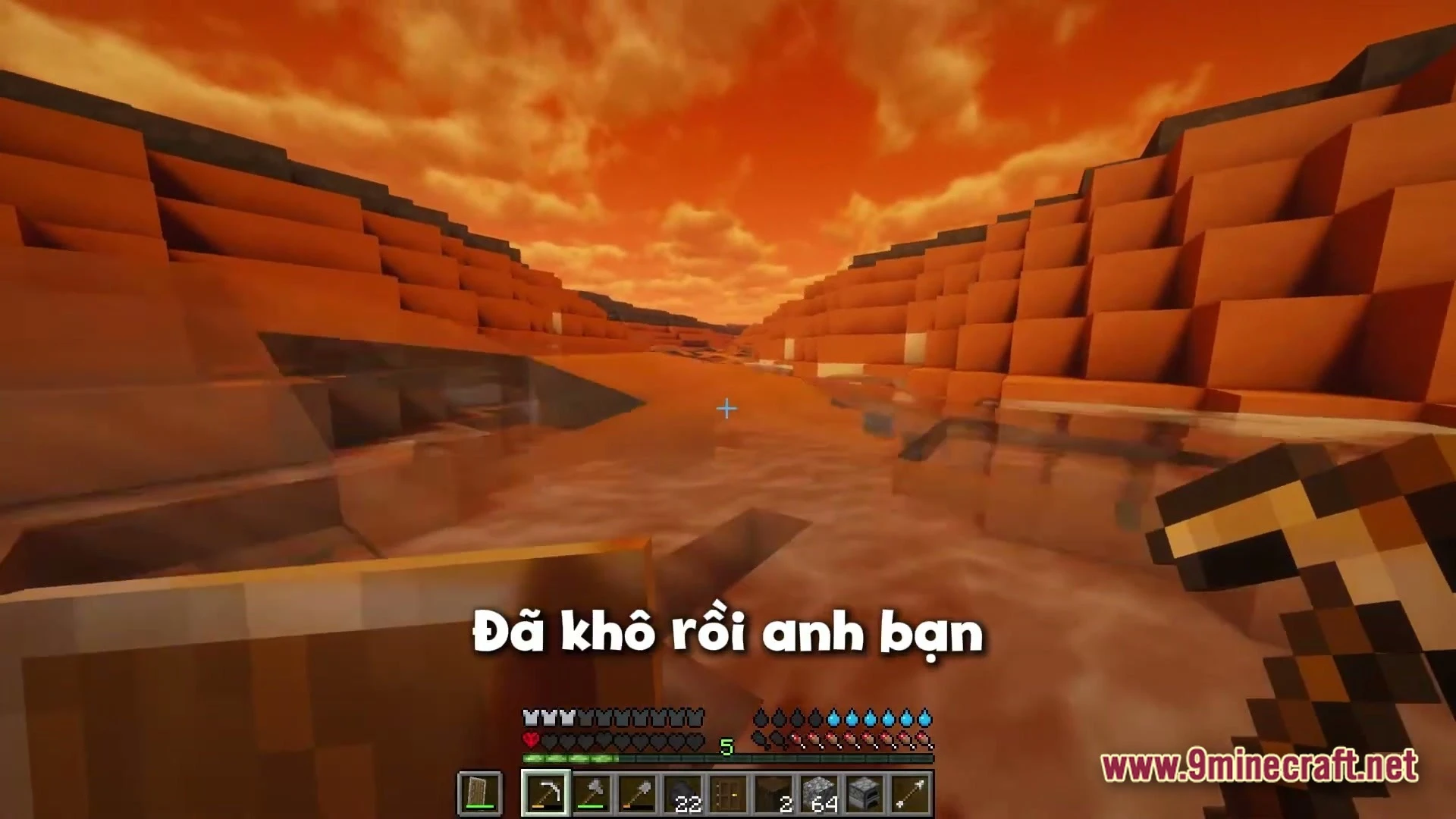 Titan Questline Apex Modpack (1.21.1) – Scorching Sun Hardcore Survival 2 A player explores a desert canyon landscape with orange hills under a bright sunset sky