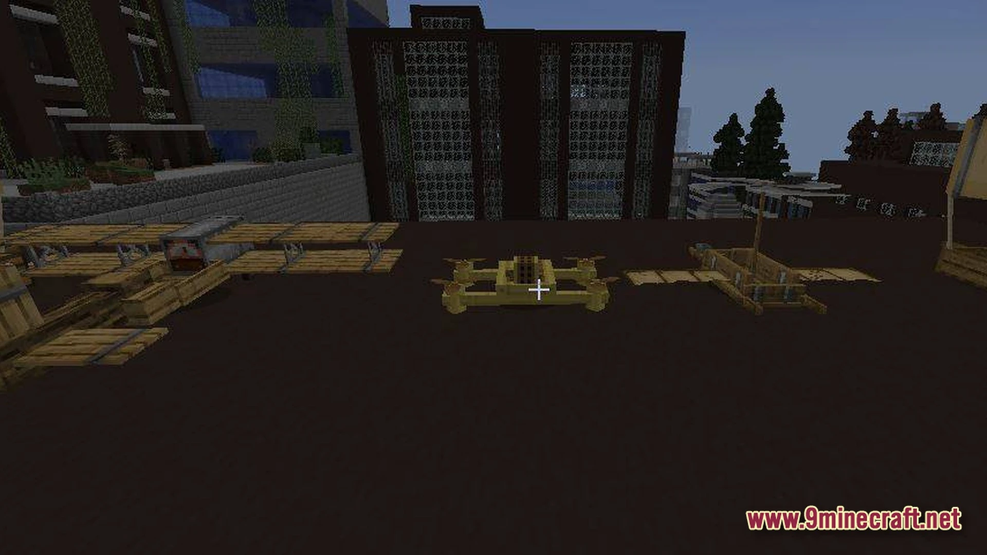 Various wooden aircraft and drones sit on a dark rooftop within a post-apocalyptic city environment