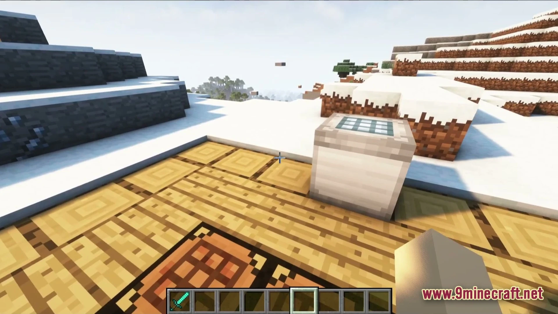 A crafting table and a solar panel machine placed on wooden planks in a snowy biome