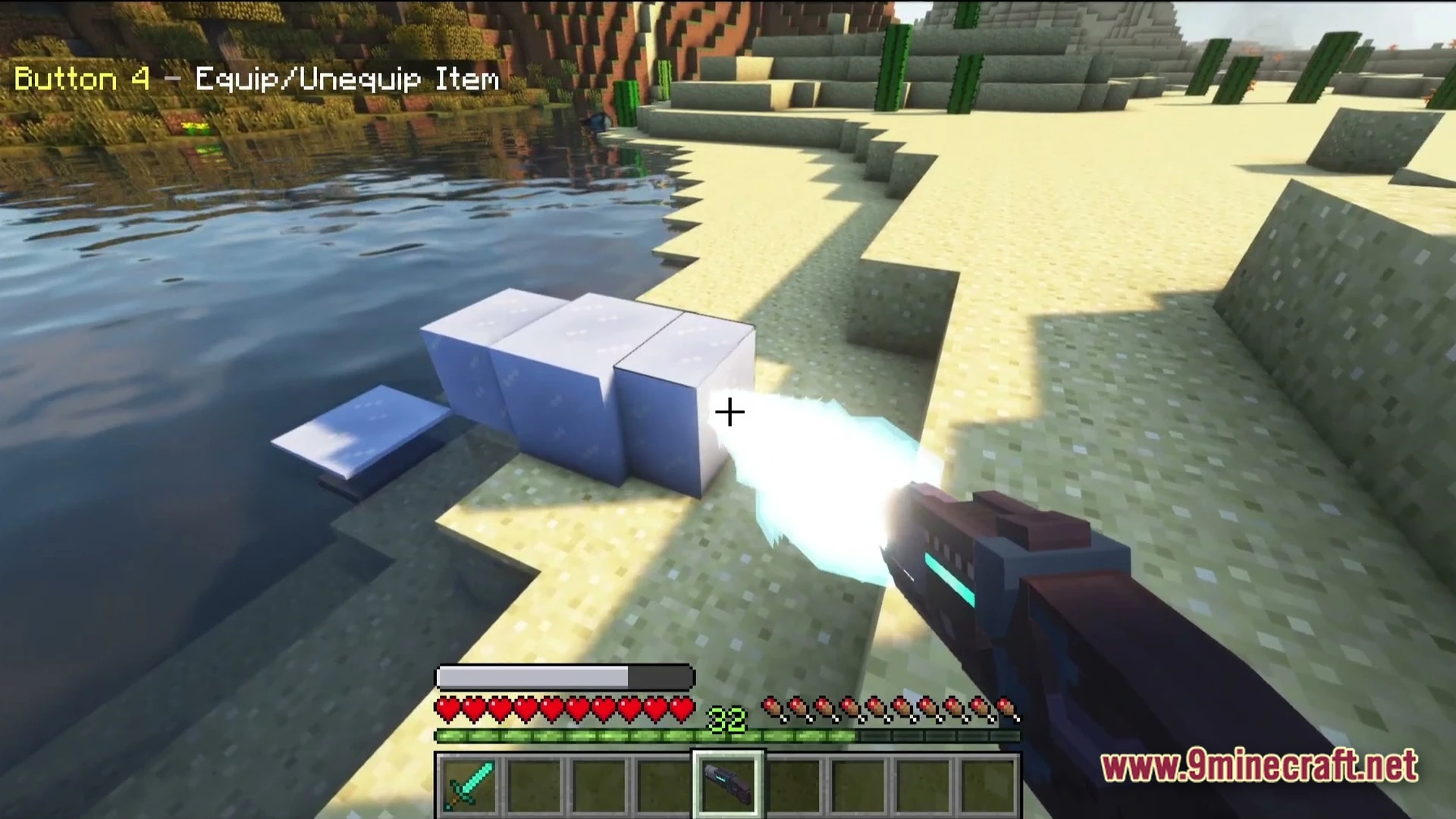 A player uses a futuristic energy weapon to freeze water into ice blocks in a desert biome