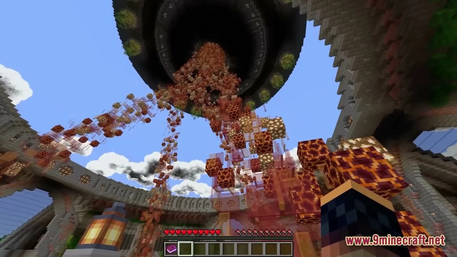 A large circular structure in the sky releases a stream of magma and glowstone blocks downward