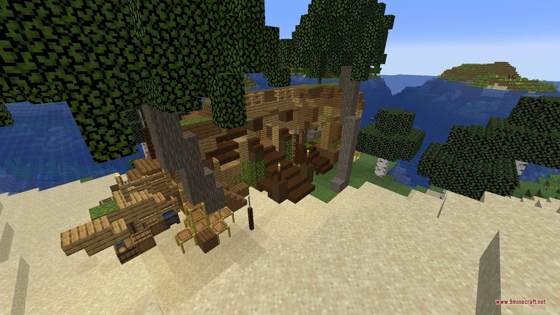 Large wooden structure with stairs built on a beach next to the water