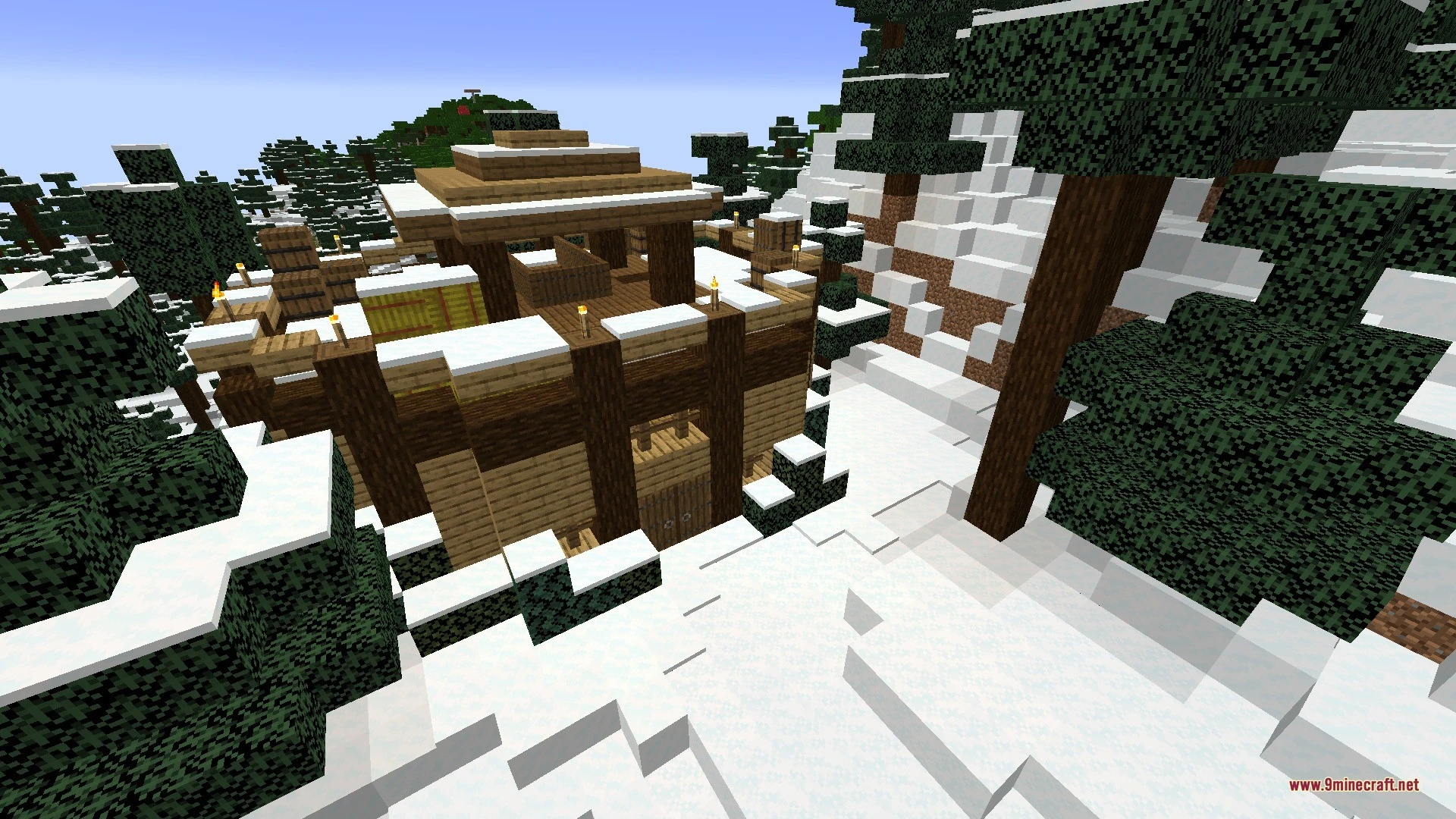 A large wooden cabin with snow on the roof in a snowy forest