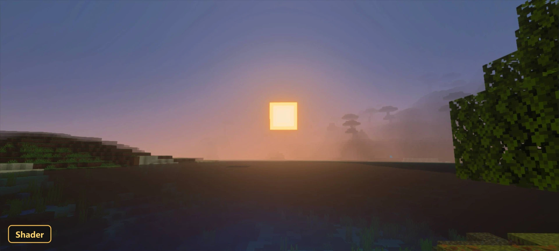 Sunset over a calm body of water with distant misty land